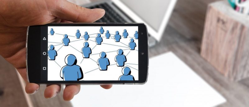 The photo depicts people connecting through social media